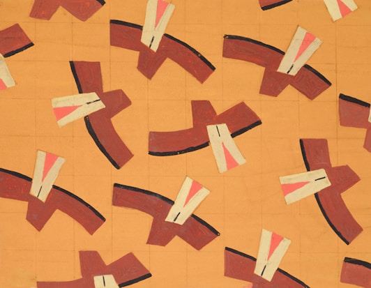 A repetitive geometric pattern featuring brown and beige shapes with accents of black and pink arranged on a grid-like orange background. The design has a stylized, abstract appearance with dynamic positioning.