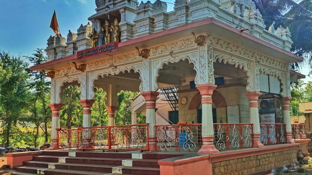 a white and red building with a red railing