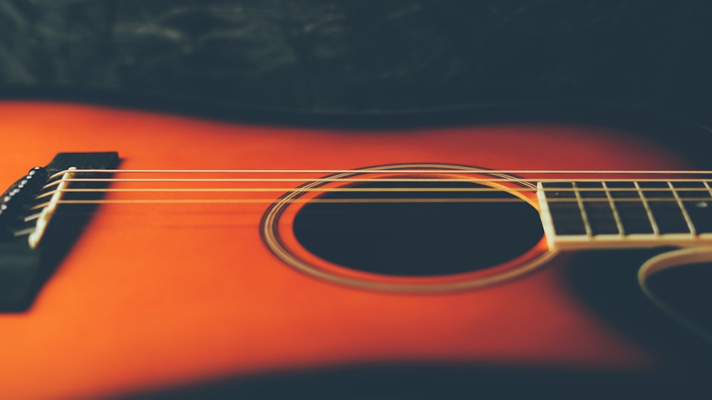 a close up of an orange acoustic guitar