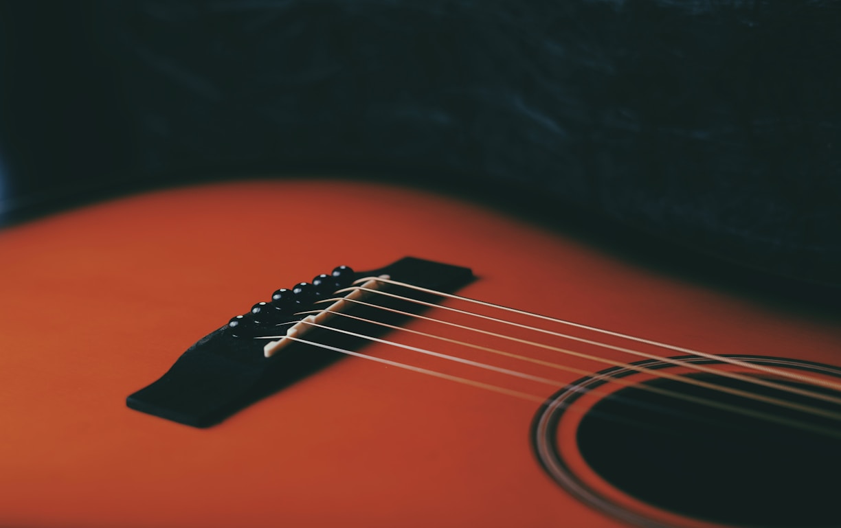 a close up of an orange acoustic guitar