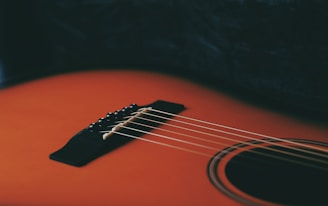 a close up of an orange acoustic guitar