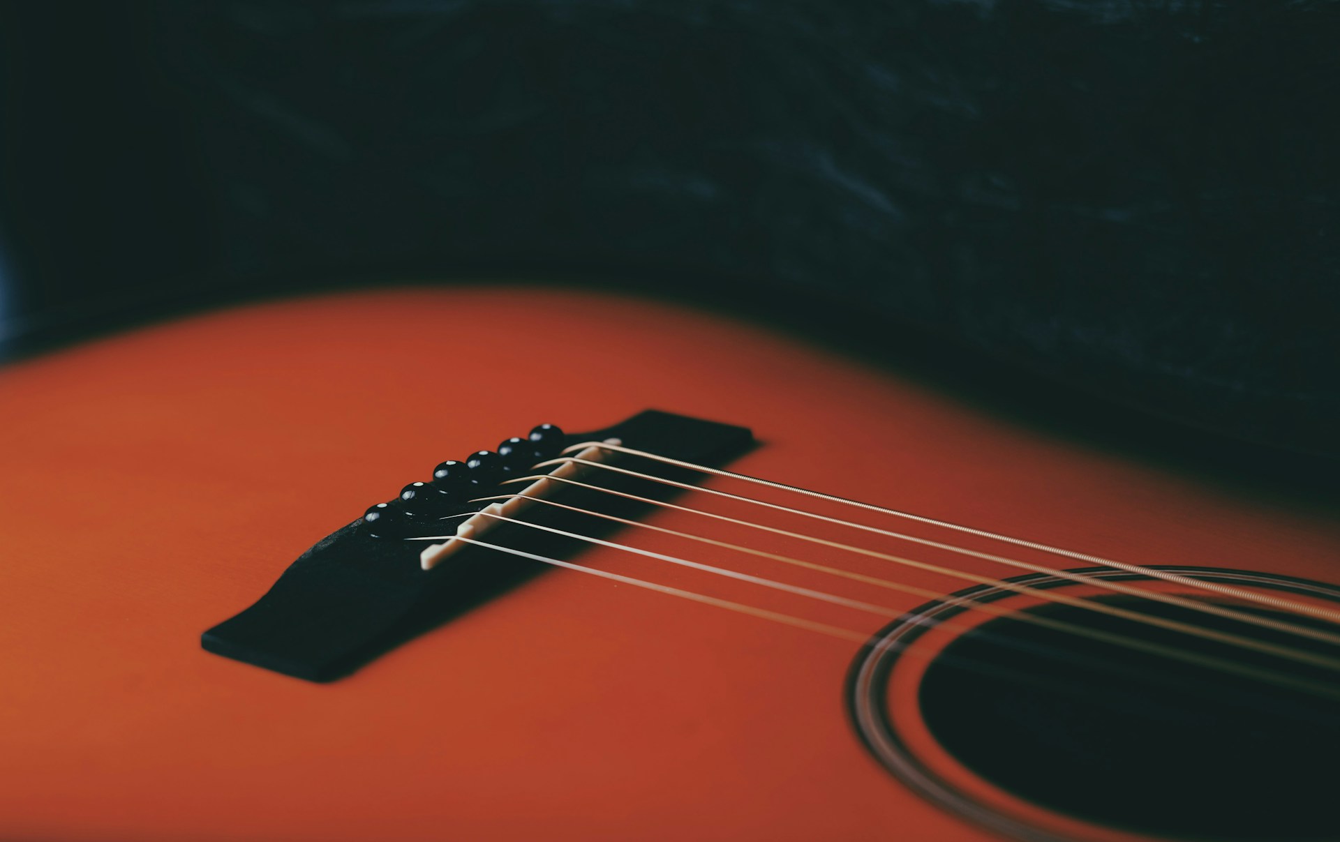 a close up of an orange acoustic guitar