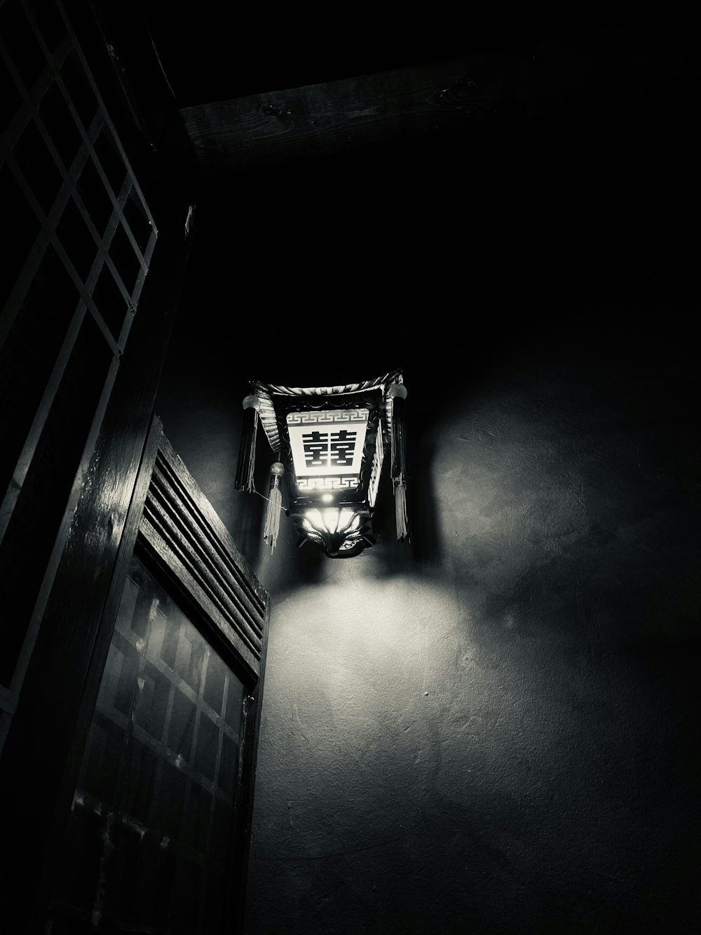 a black and white photo of a window in a dark room