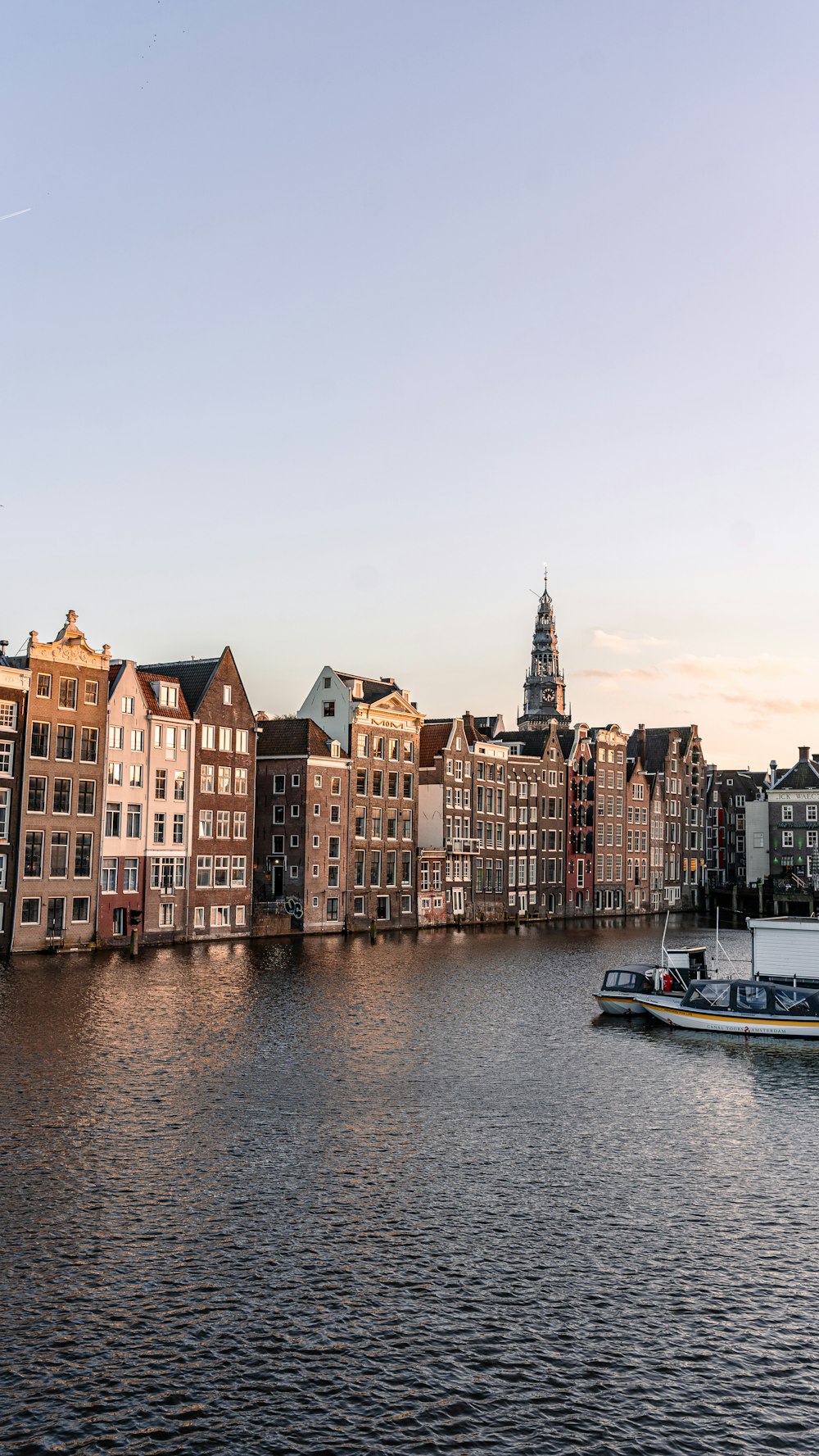 a boat traveling down a river next to tall buildings