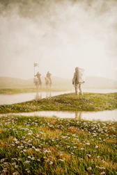 a group of people riding horses on a foggy day