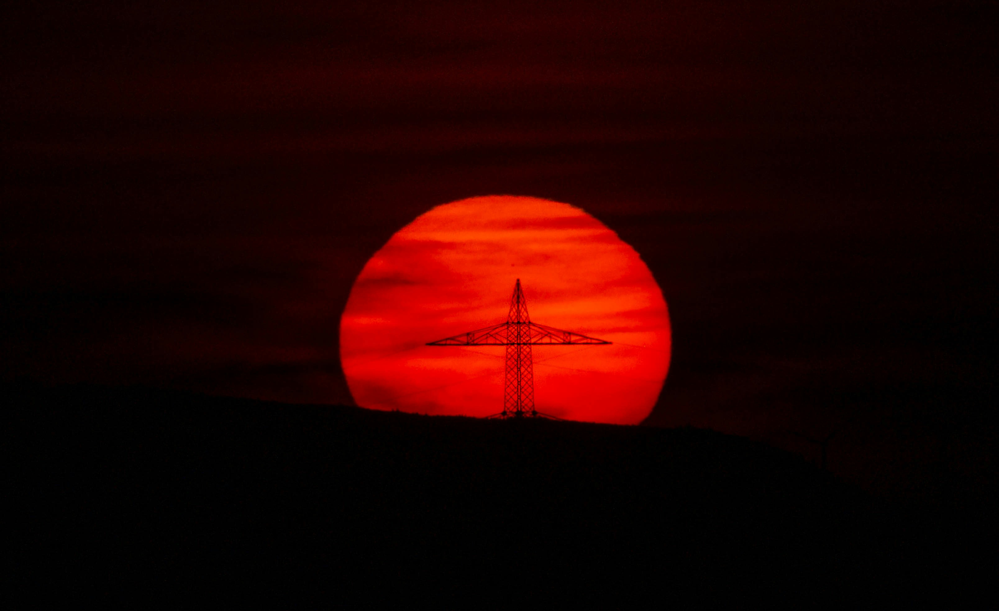 the sun is setting behind a radio tower