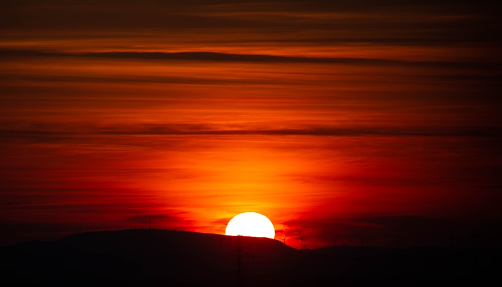 the sun is setting over a mountain range