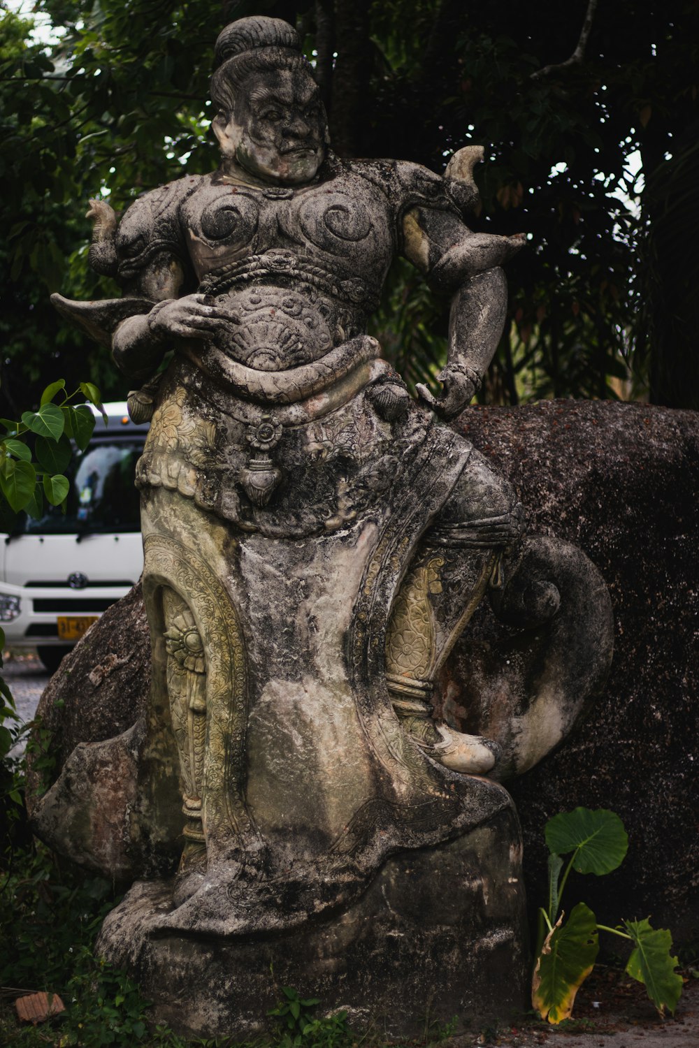 uma estátua de um homem sentado em cima de uma rocha