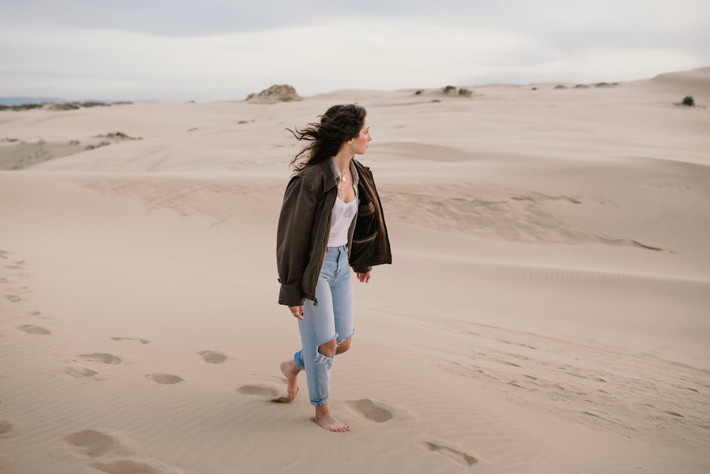 a woman standing on top of a sandy beach