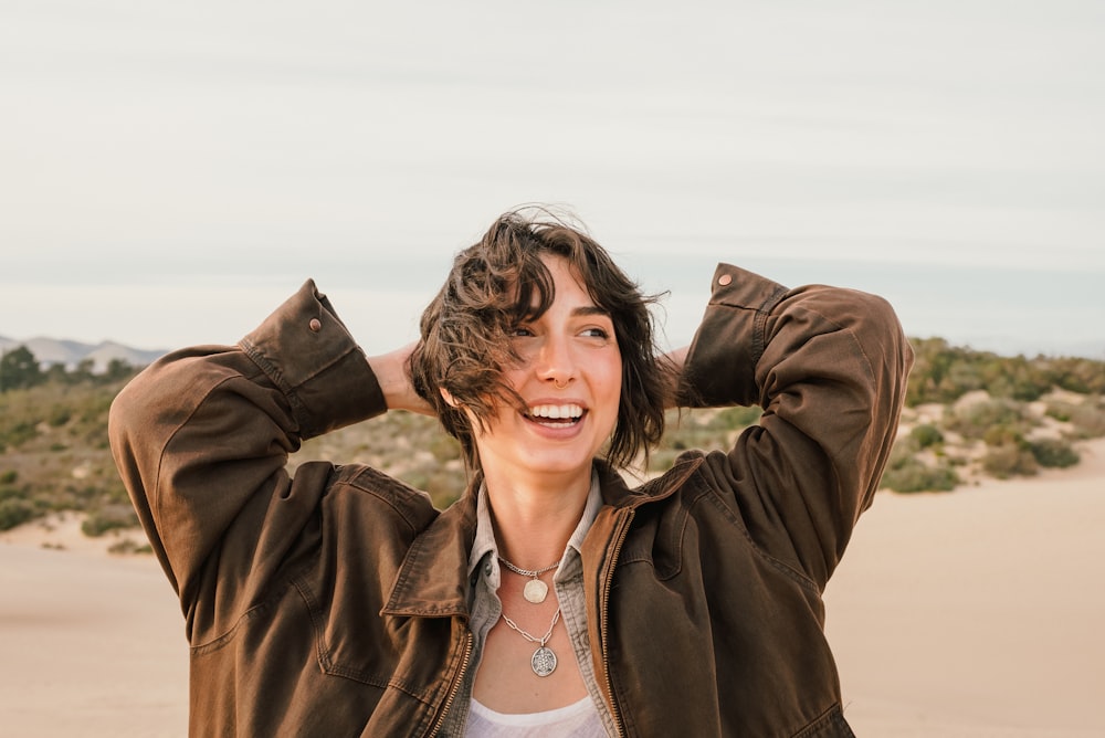 a woman with her hands on her head smiling