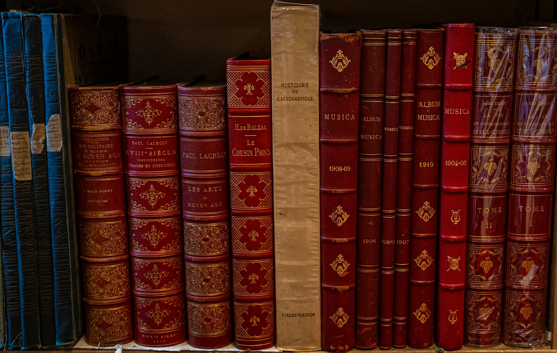 a row of red books sitting on top of a shelf