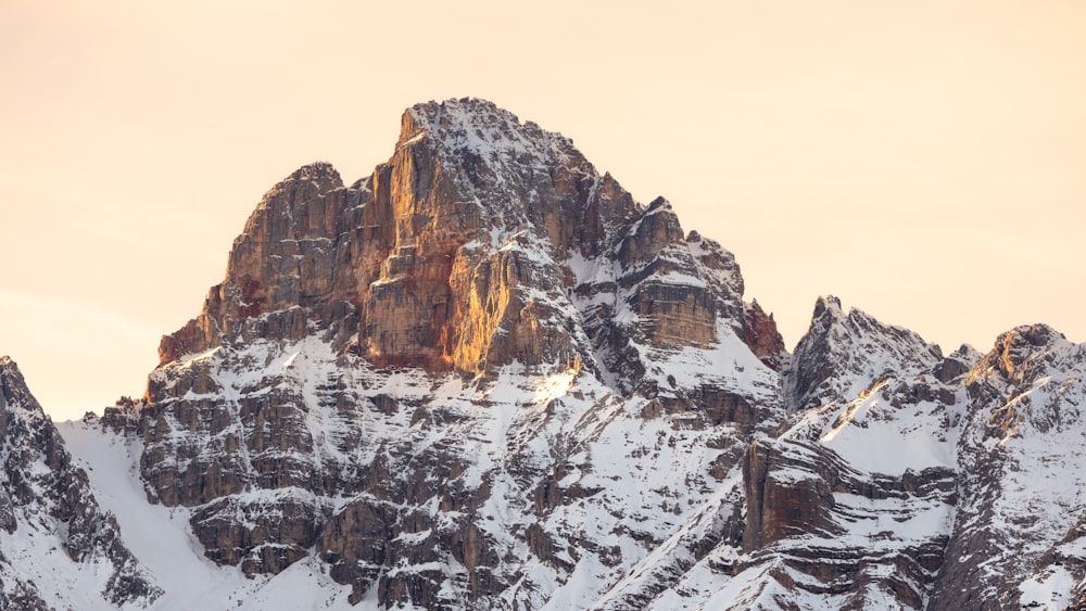 a mountain covered in snow with a sky background