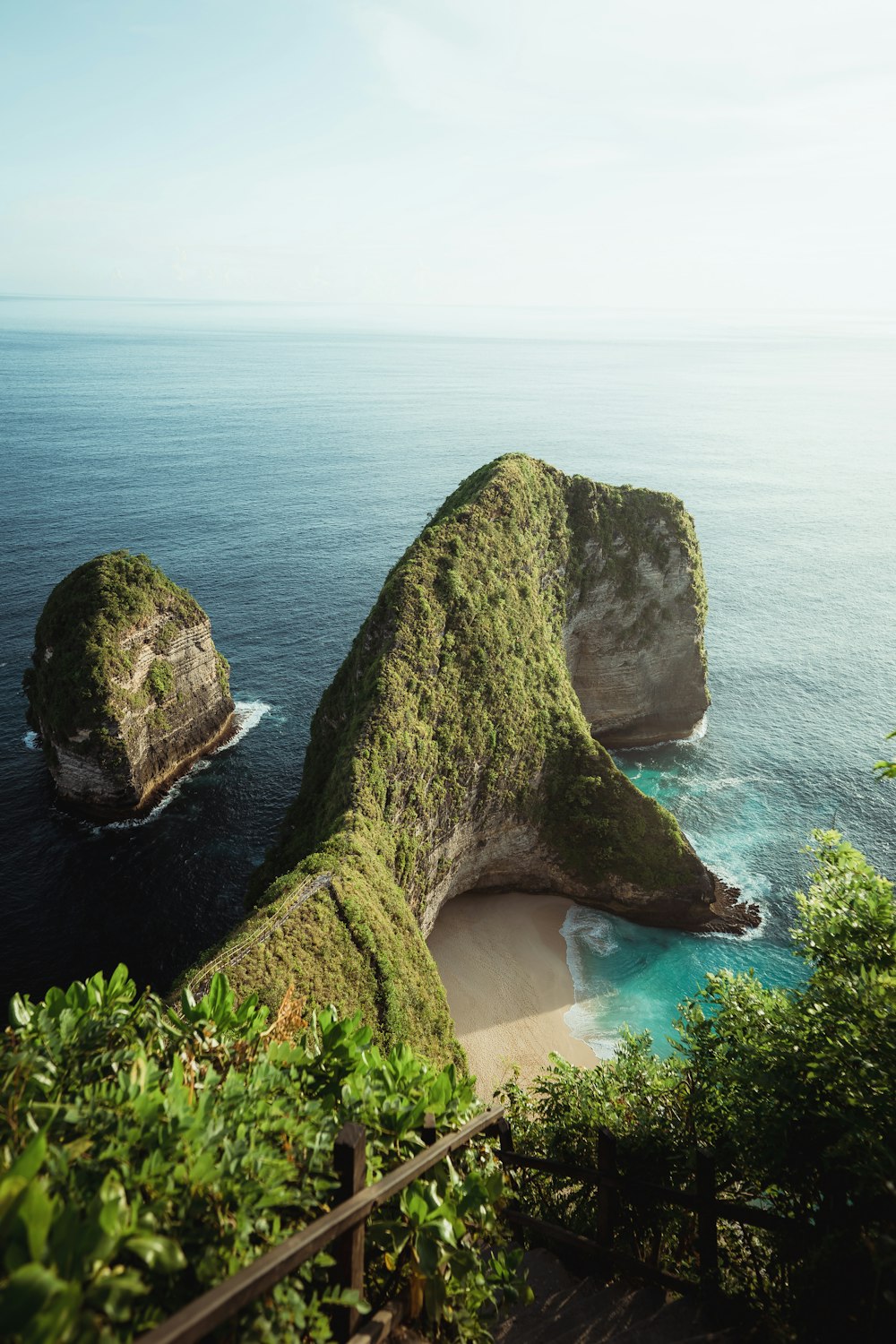 a couple of large rocks sitting on top of a lush green hillside