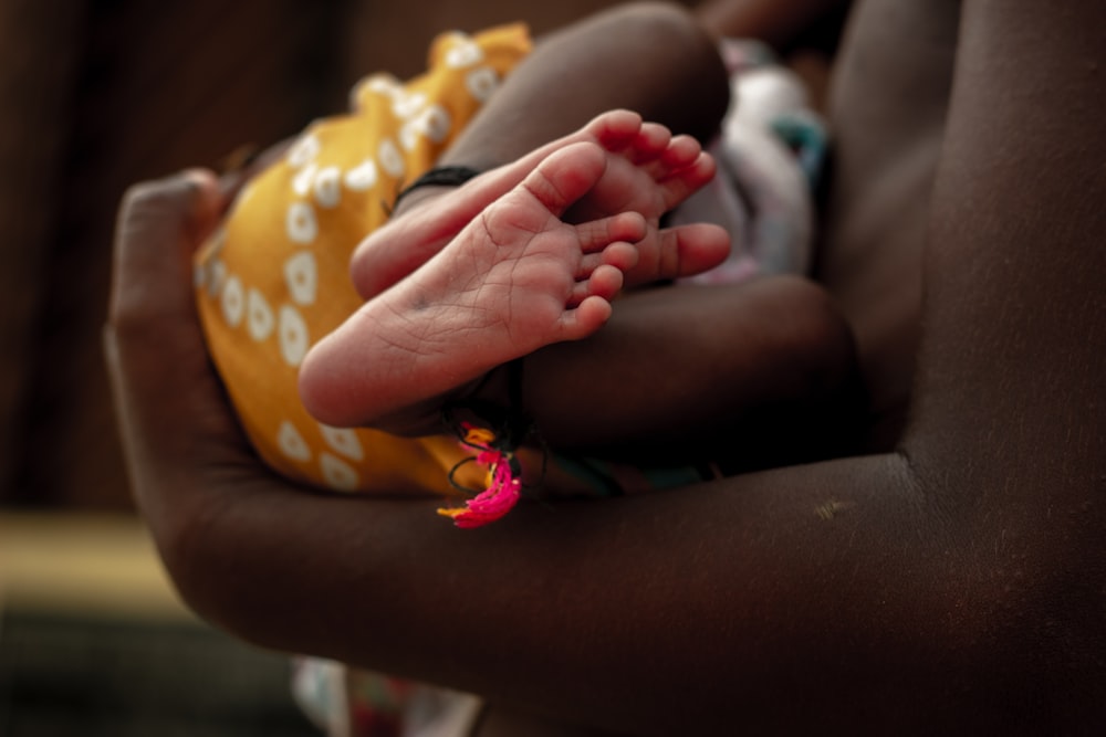 a close up of a person holding a baby