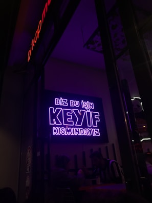 KYM Elektronik logosu önünde gülümseyen ekip üyeleri.