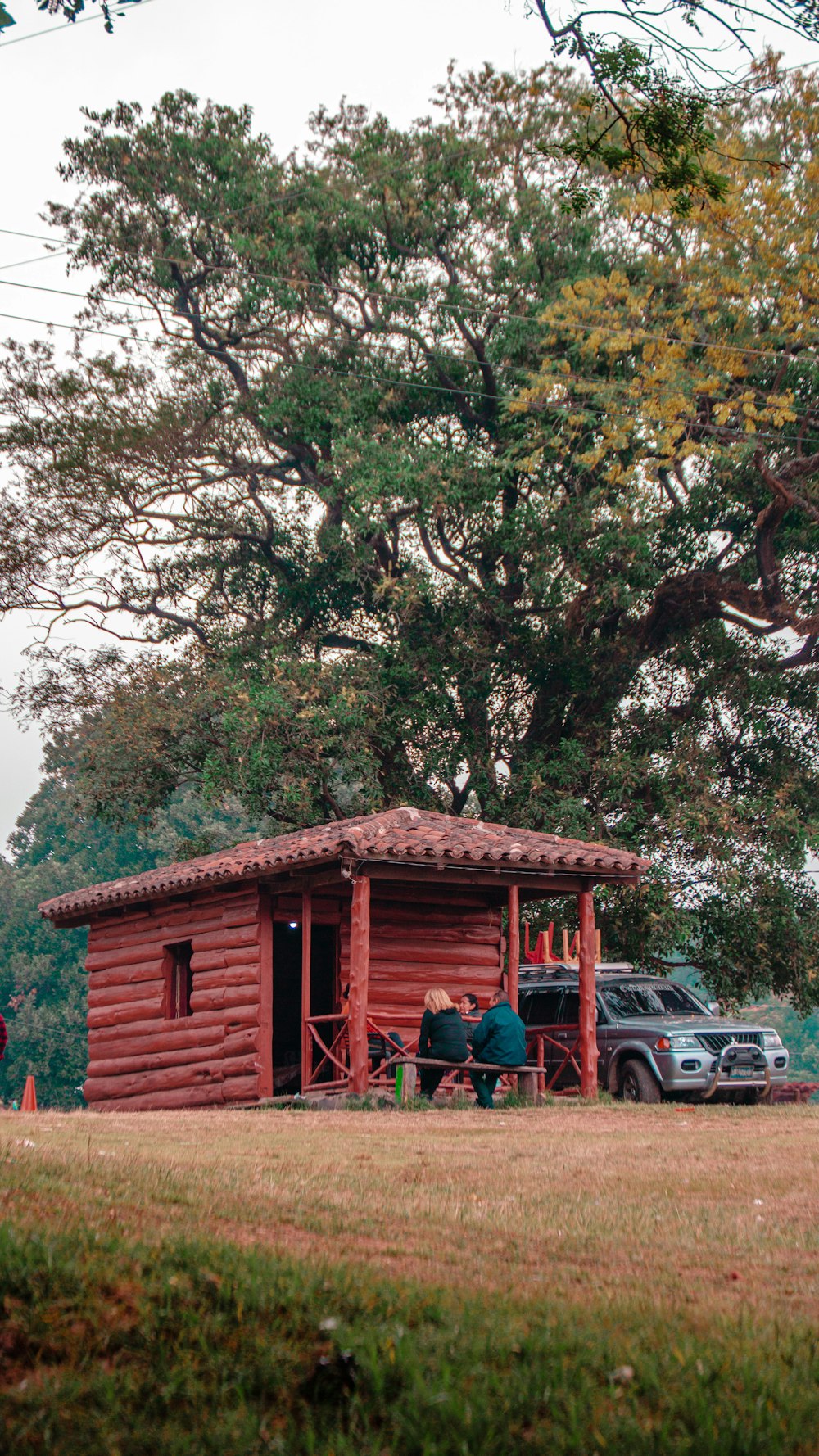 a couple of people standing in front of a log cabin