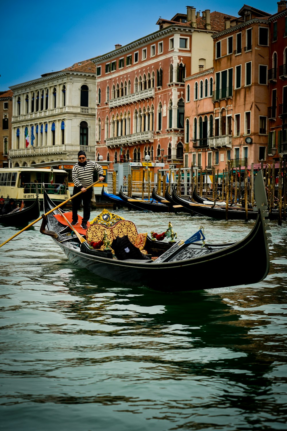 a man riding a boat down a river next to tall buildings