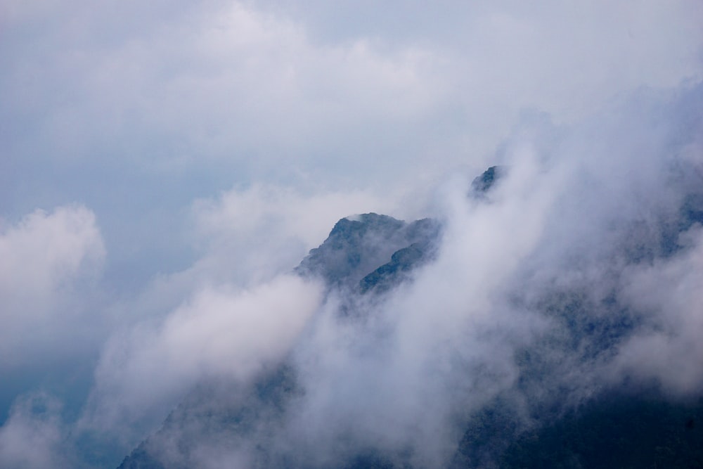 a view of the top of a mountain covered in clouds