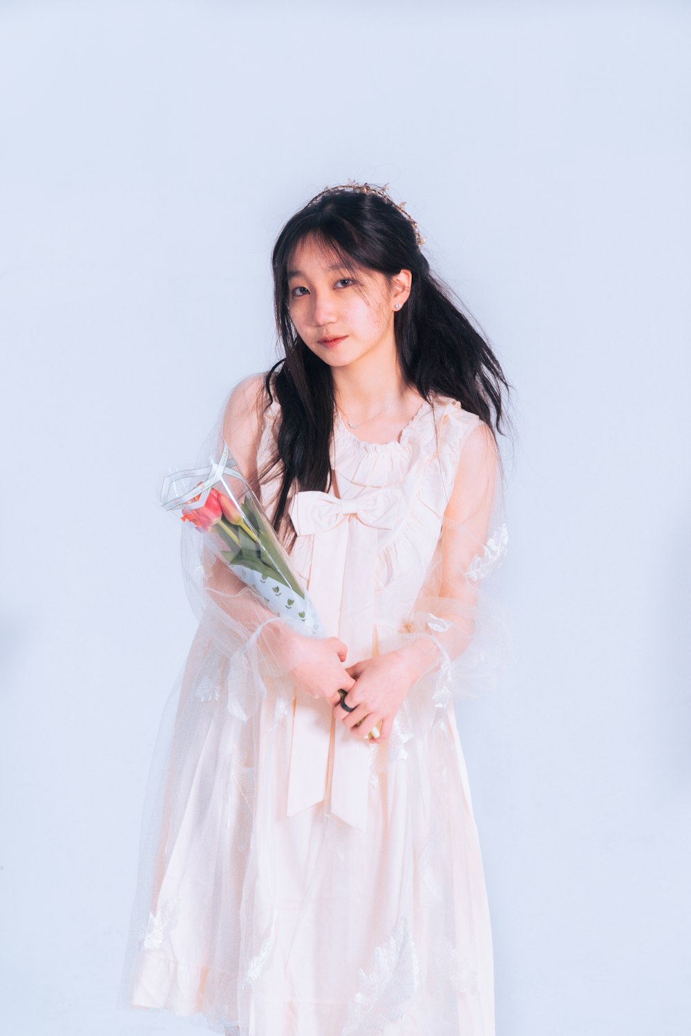 a girl in a white dress holding a bouquet of flowers