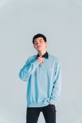 Model wearing a sleek, professional blue hoodie against a white background.