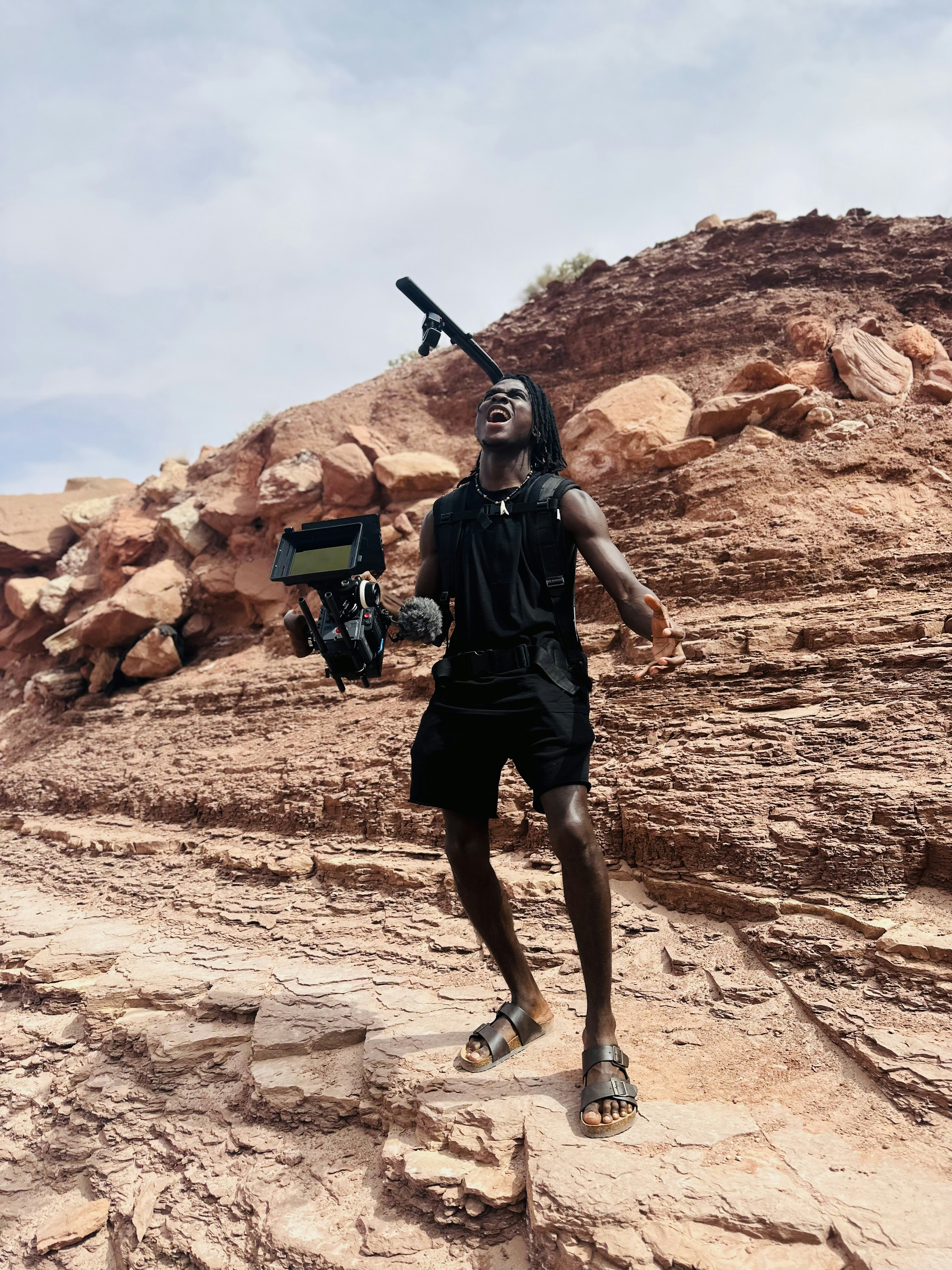 a man holding a baseball bat on top of a rocky hillside