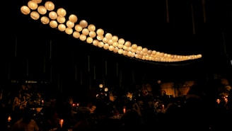 A cozy evening scene with softly glowing lanterns and joyful faces in the crowd.