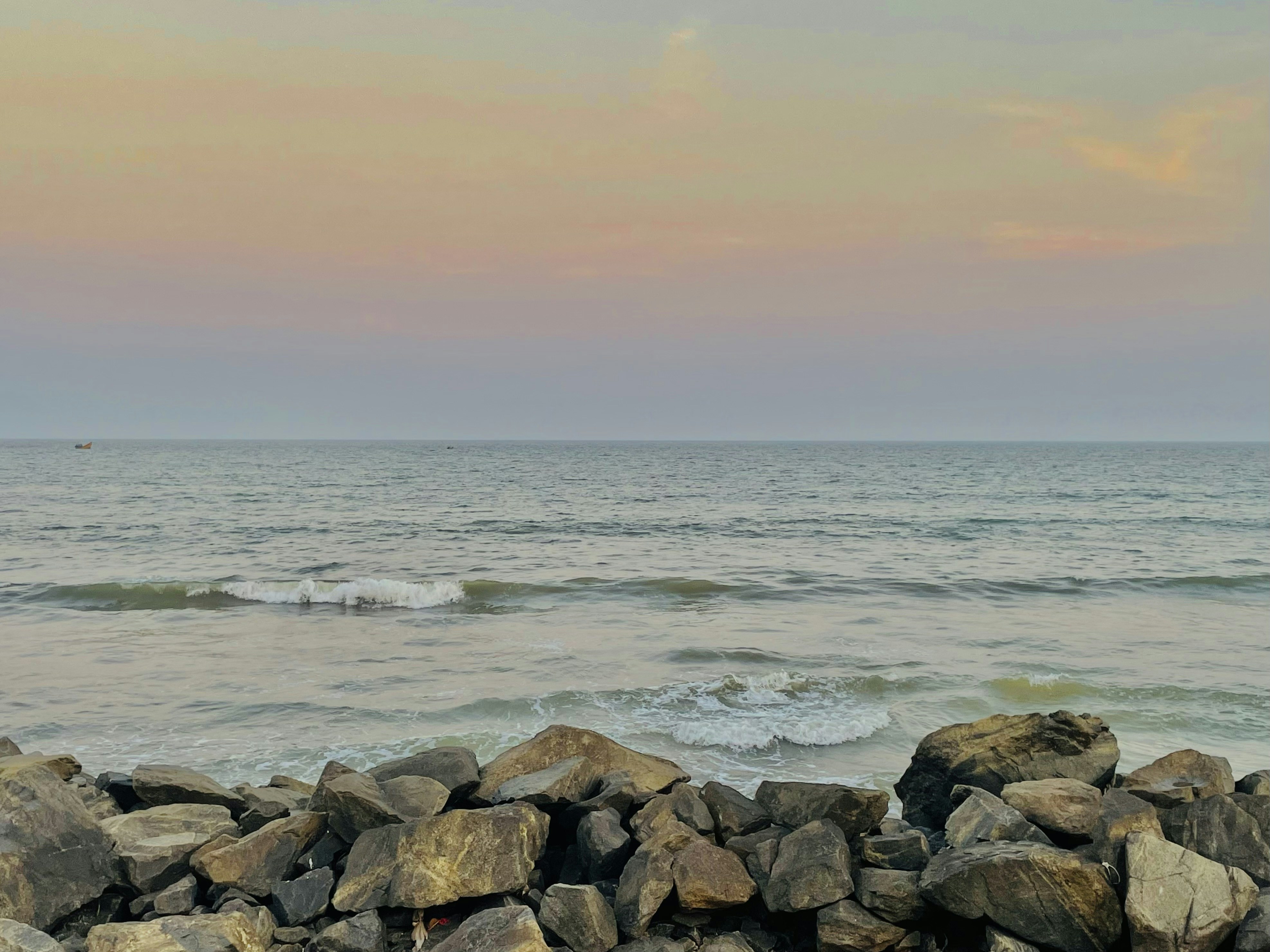 A person riding a surfboard on top of a pile of rocks photo – Free ...