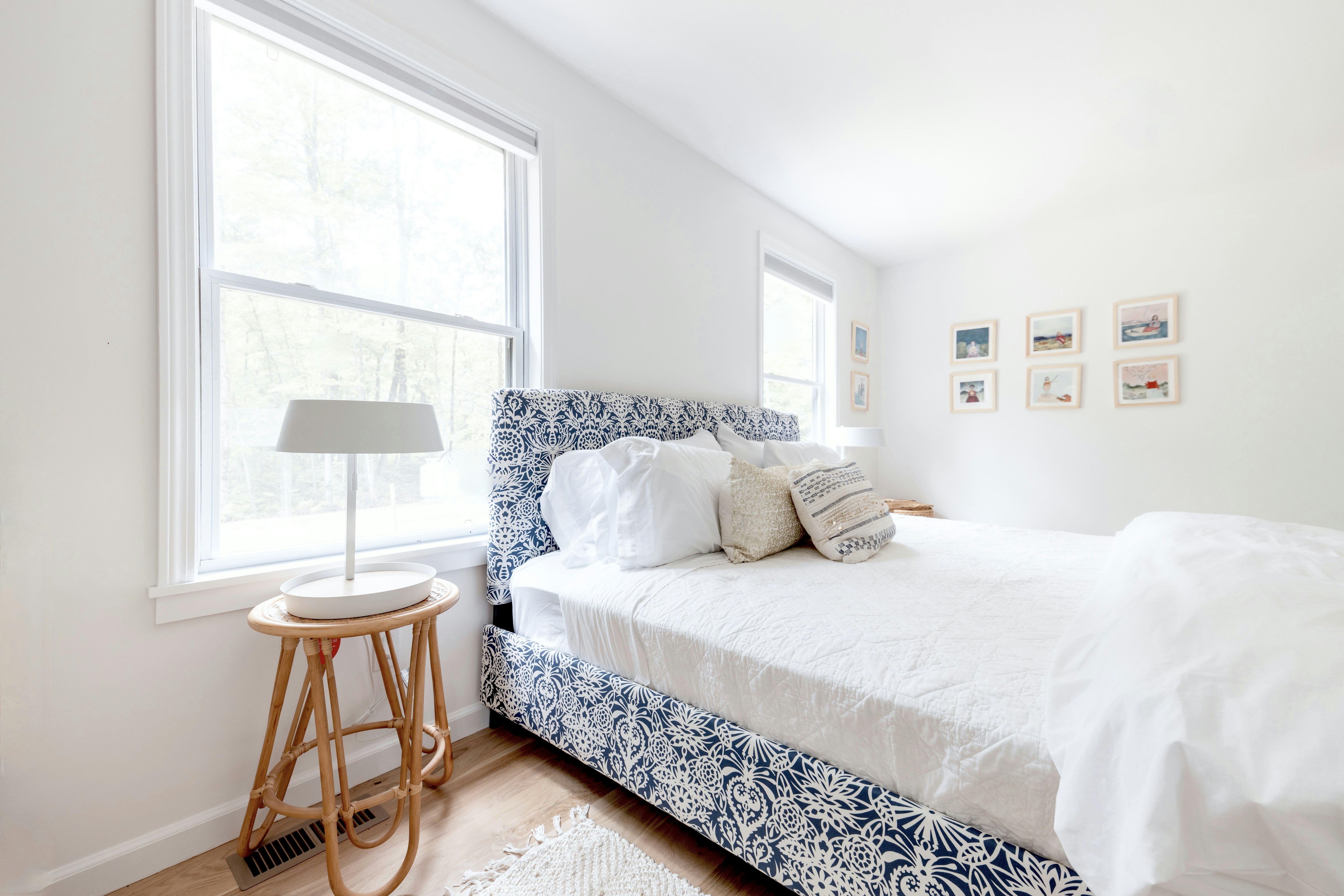 a bedroom with a white bed and blue and white bedding