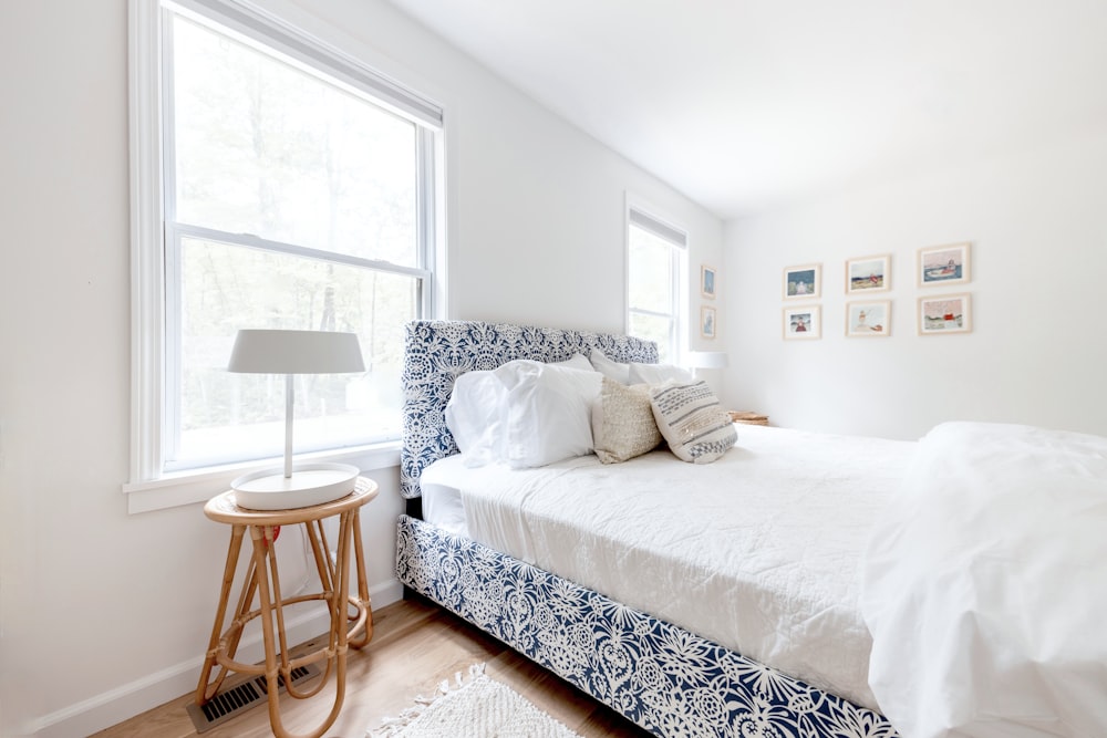 a bedroom with a white bed and blue and white bedding