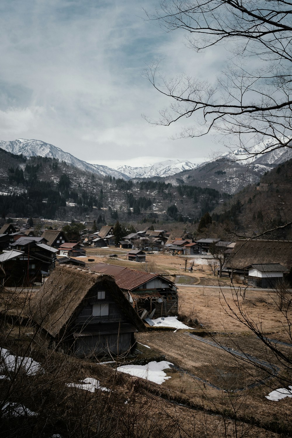 a small village in the mountains with snow on the ground