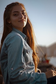 A vibrant portrait of a young woman smiling naturally during golden hour outdoors.