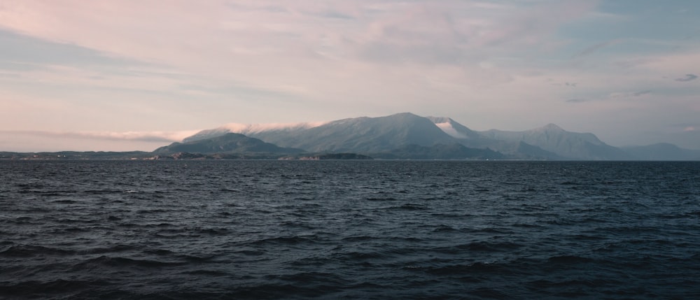 a large body of water with mountains in the background