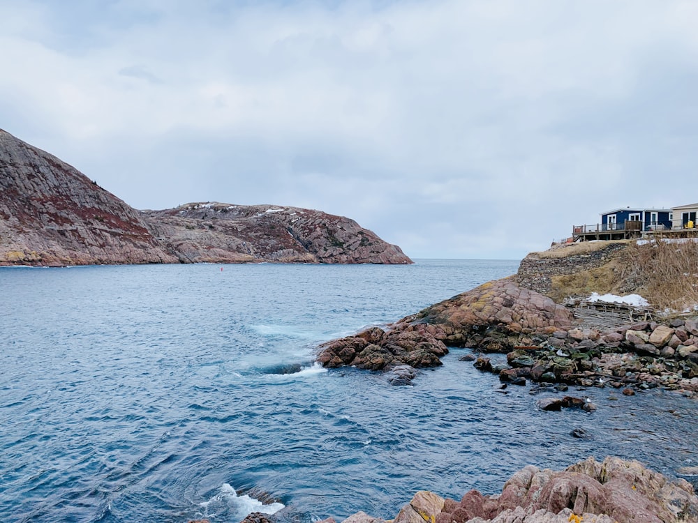 a large body of water next to a rocky shore