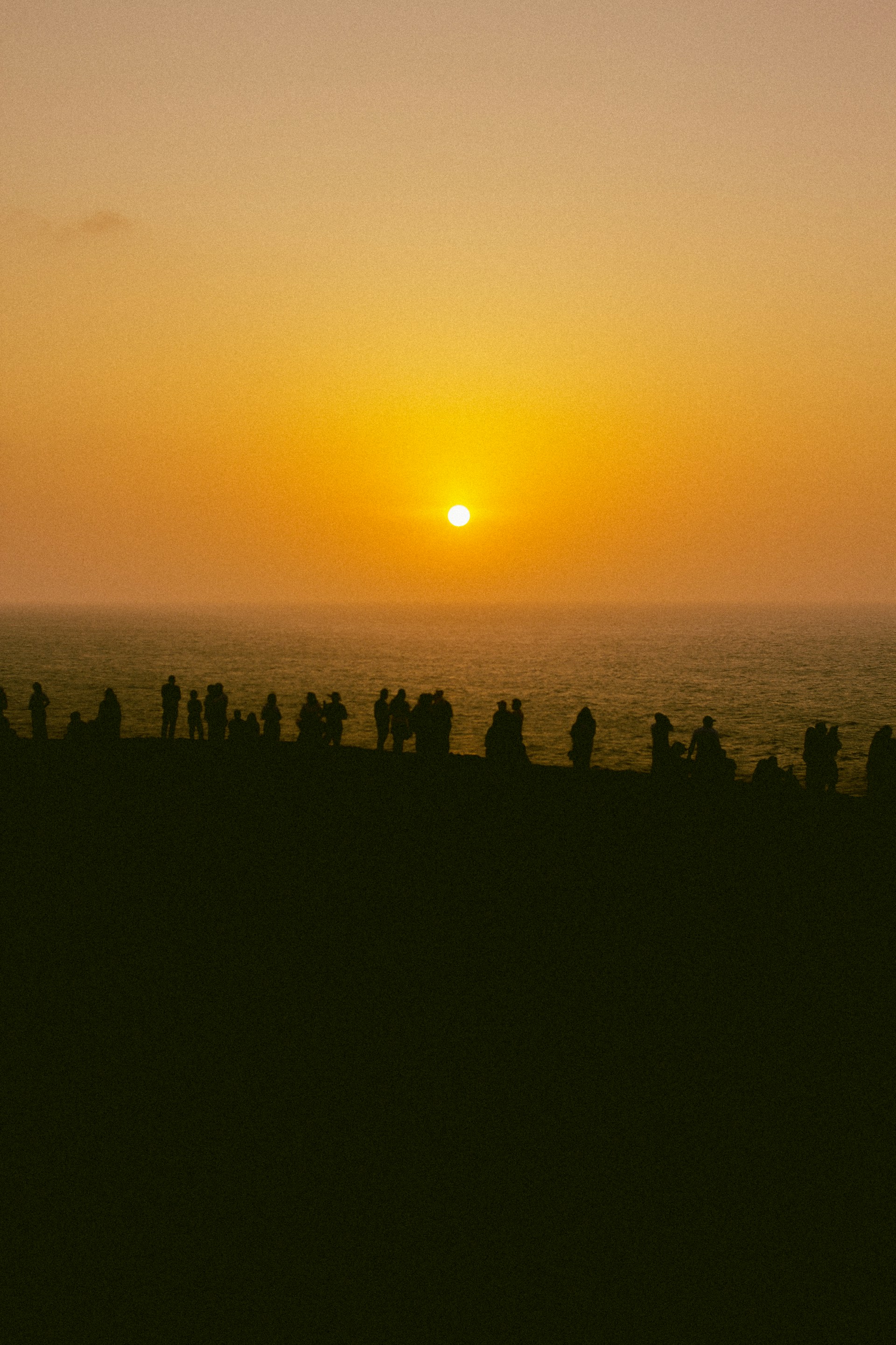 a group of people standing on top of a beach