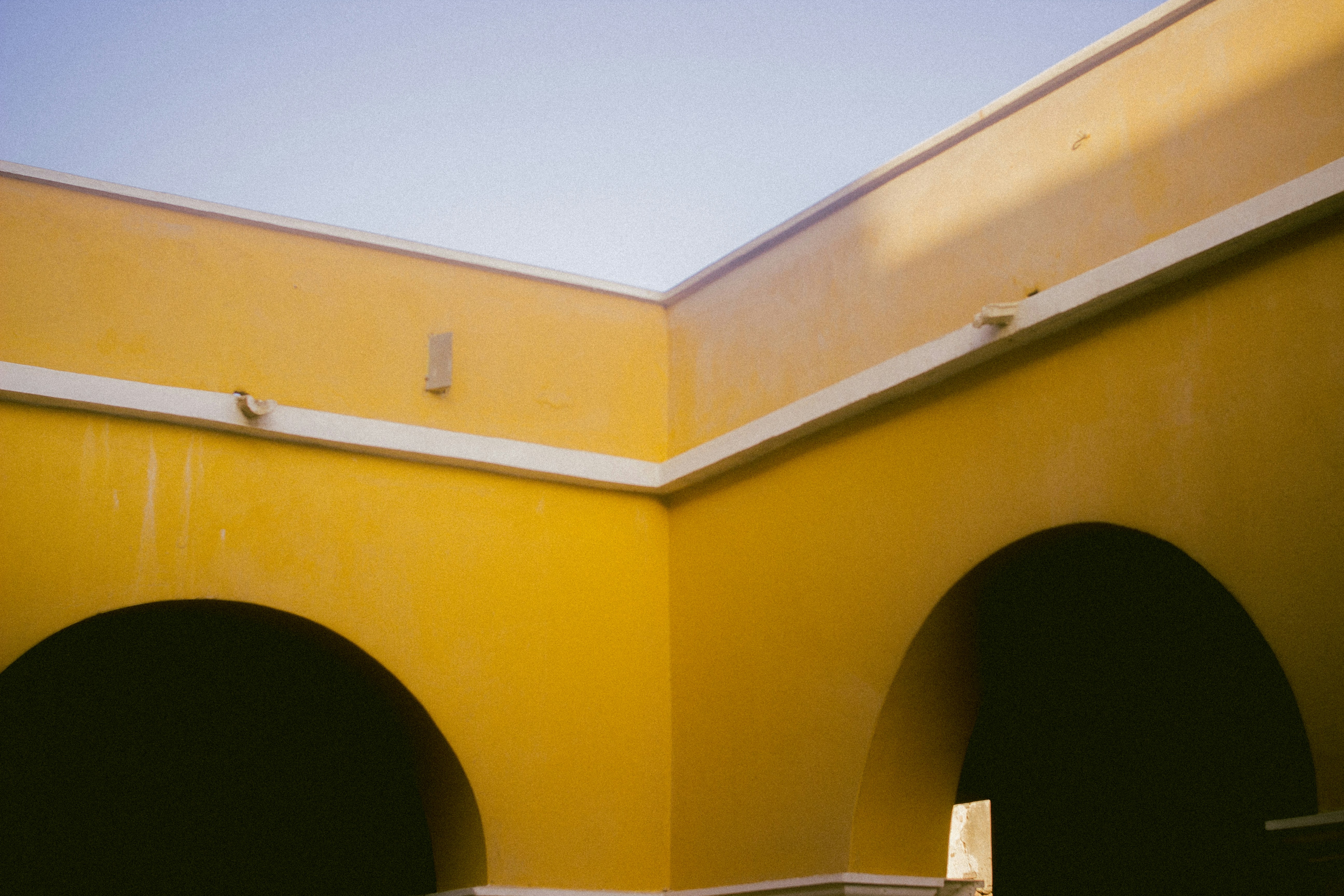 a yellow building with a clock on the side of it