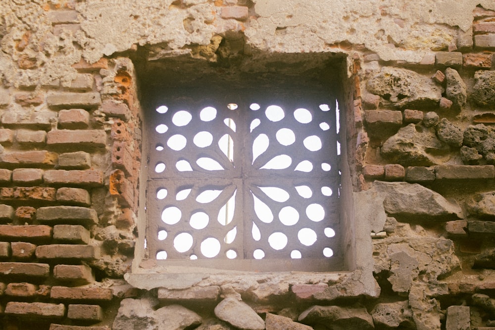 a window in a brick wall with holes in it