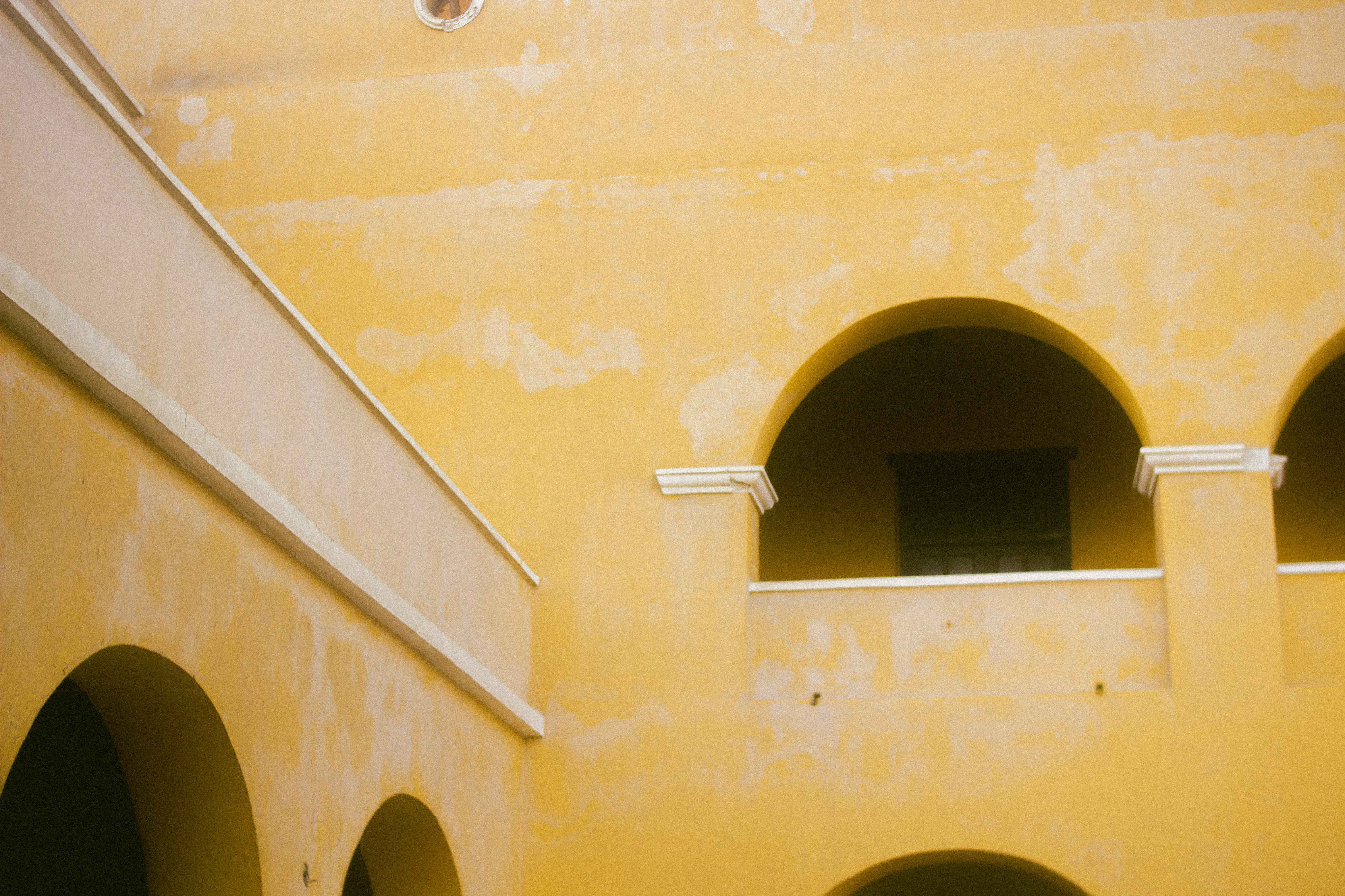 a building with arches and a clock on the wall