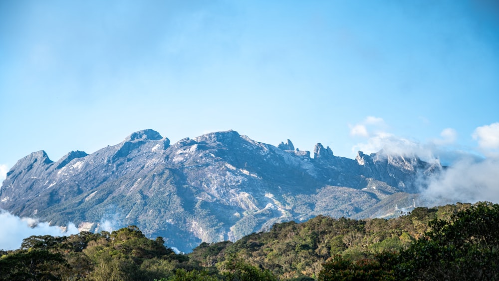 a view of a mountain range with clouds in the foreground