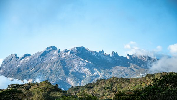 A view of a mountain range with clouds in the foreground — Kota Kinabalu, Malaysia