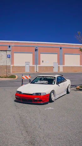 Side view of a Mustang GT parked on a city street, showcasing aggressive aftermarket wheels and lowered suspension.