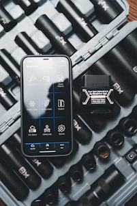 a cell phone sitting on top of a case filled with tools