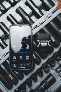 a cell phone sitting on top of a case filled with tools