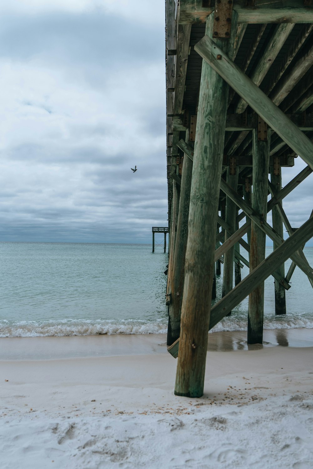 a view of the ocean from underneath a pier