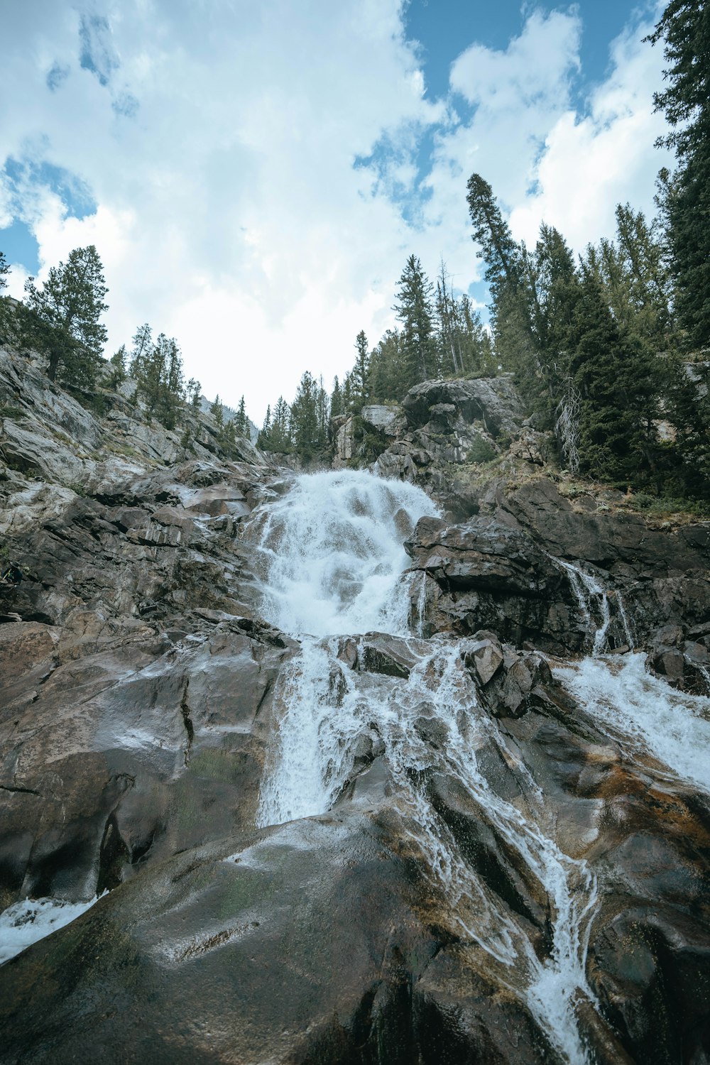 a waterfall is flowing down a rocky mountain