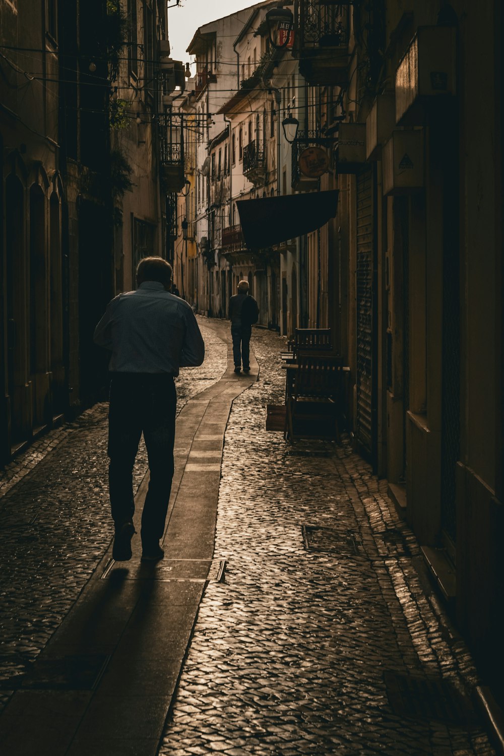 Un homme marchant dans une rue tenant un parapluie