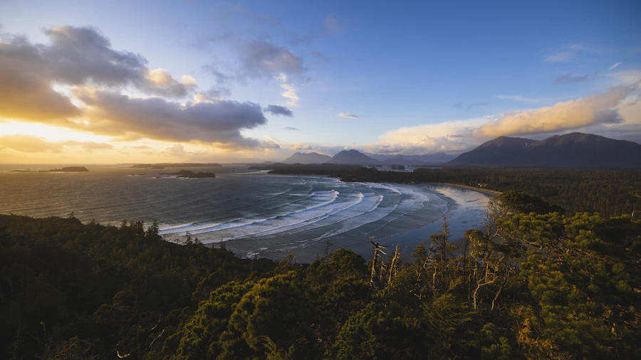 Pacific sunset over calm ocean water with mountains visible in the distance near Tofino