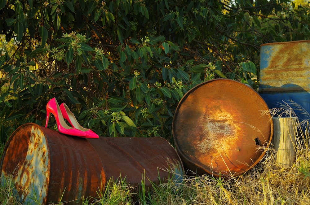 a pair of pink high heels sitting on top of a barrel