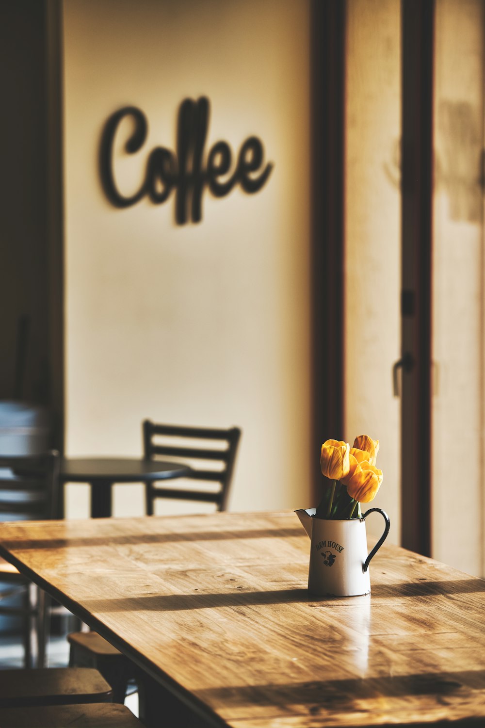 a table with a vase of yellow flowers on top of it