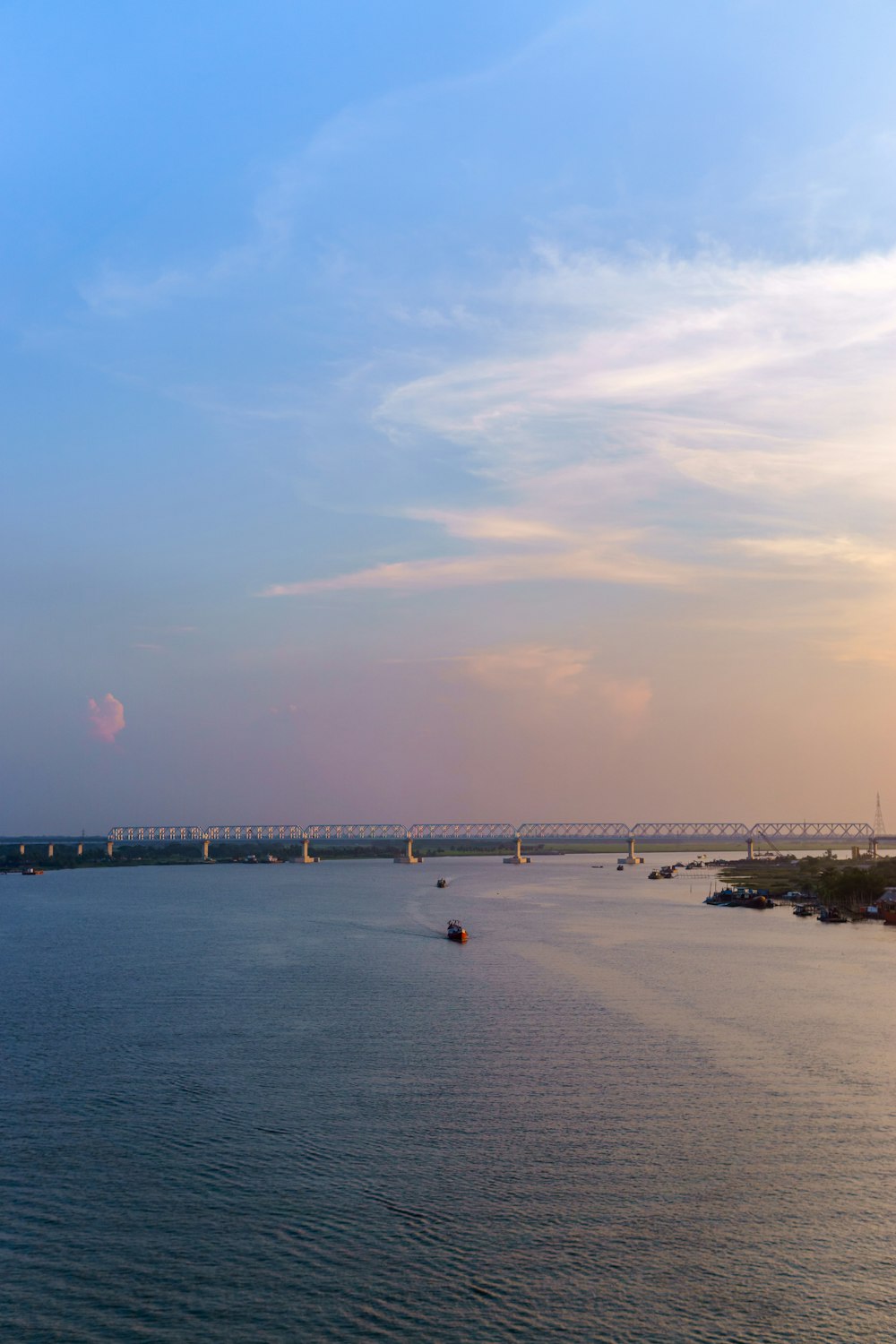 a large body of water with a bridge in the background