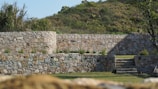 Retaining wall made of stacked stone, supporting a terraced backyard.